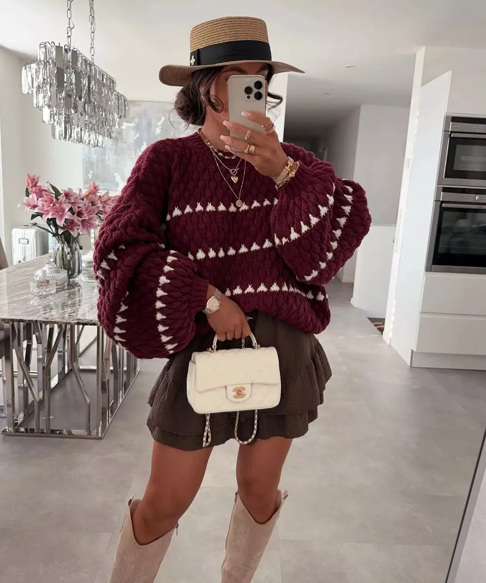 Donna con maglione bordeaux a righe bianche in interno con cappello