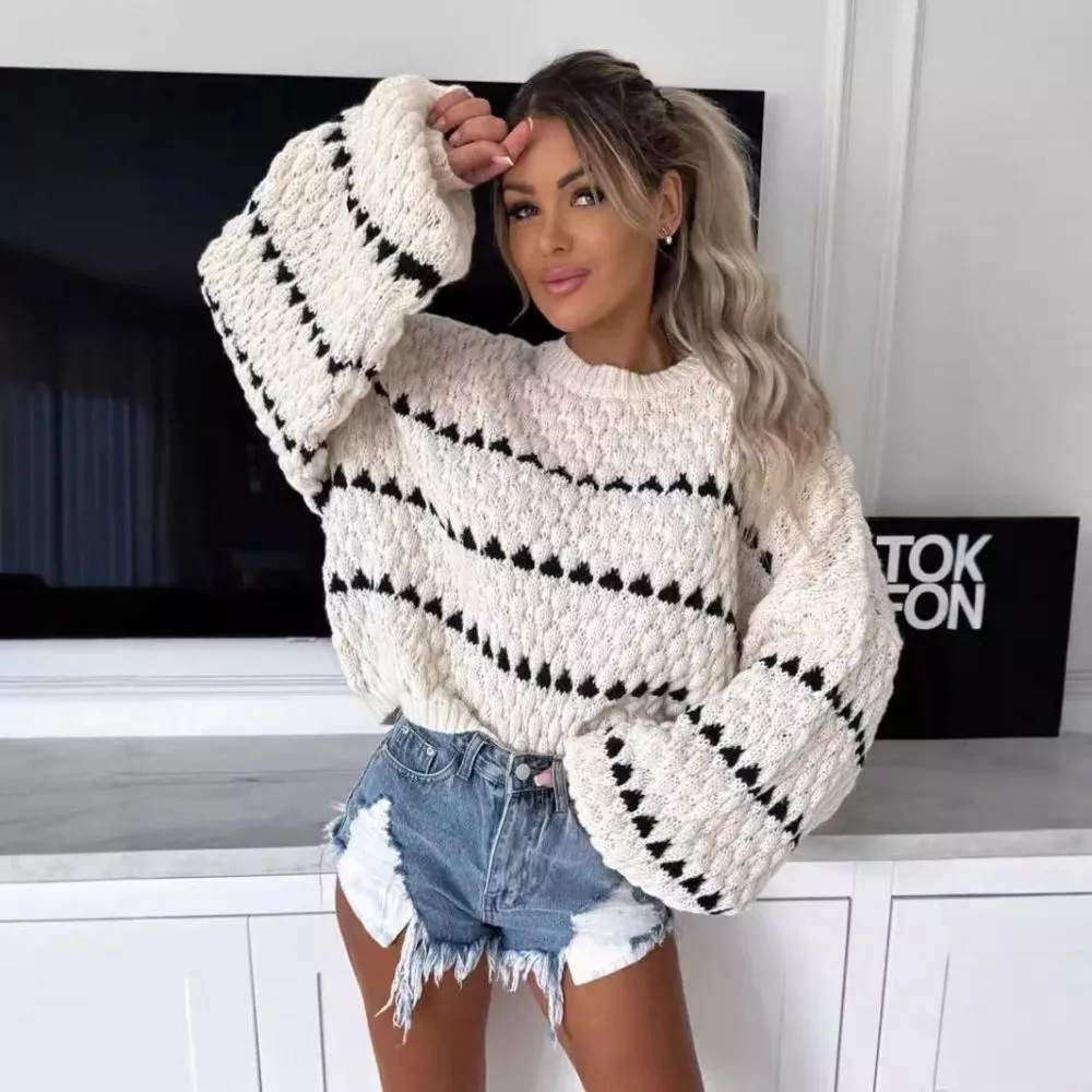 Donna con maglione bianco a righe nere con shorts jeans strappati