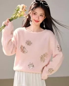 Maglione donna rosa con decorazioni in paillettes dorate indossato da modella