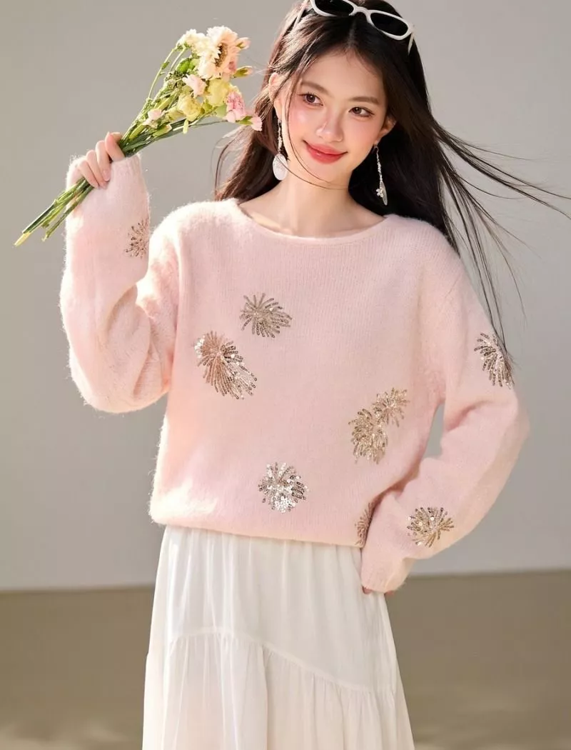 Dettaglio frontale del maglione in rosa con paillettes a forma di fuochi d'artificio