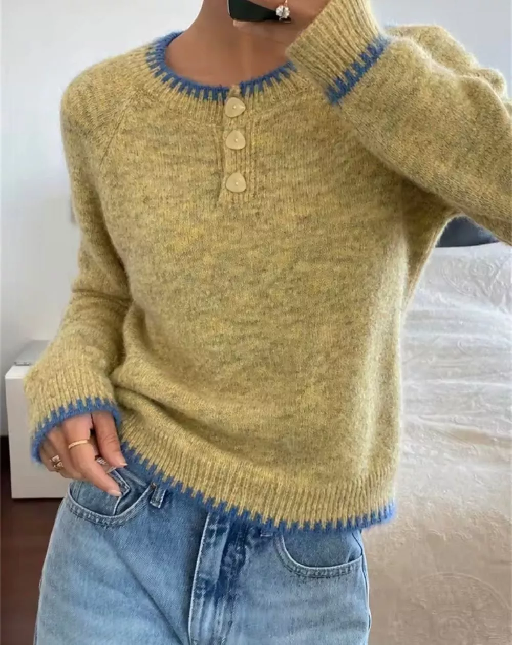 Dettaglio scollo rotondo e bottoni maglione verde con bordo blu indossato
