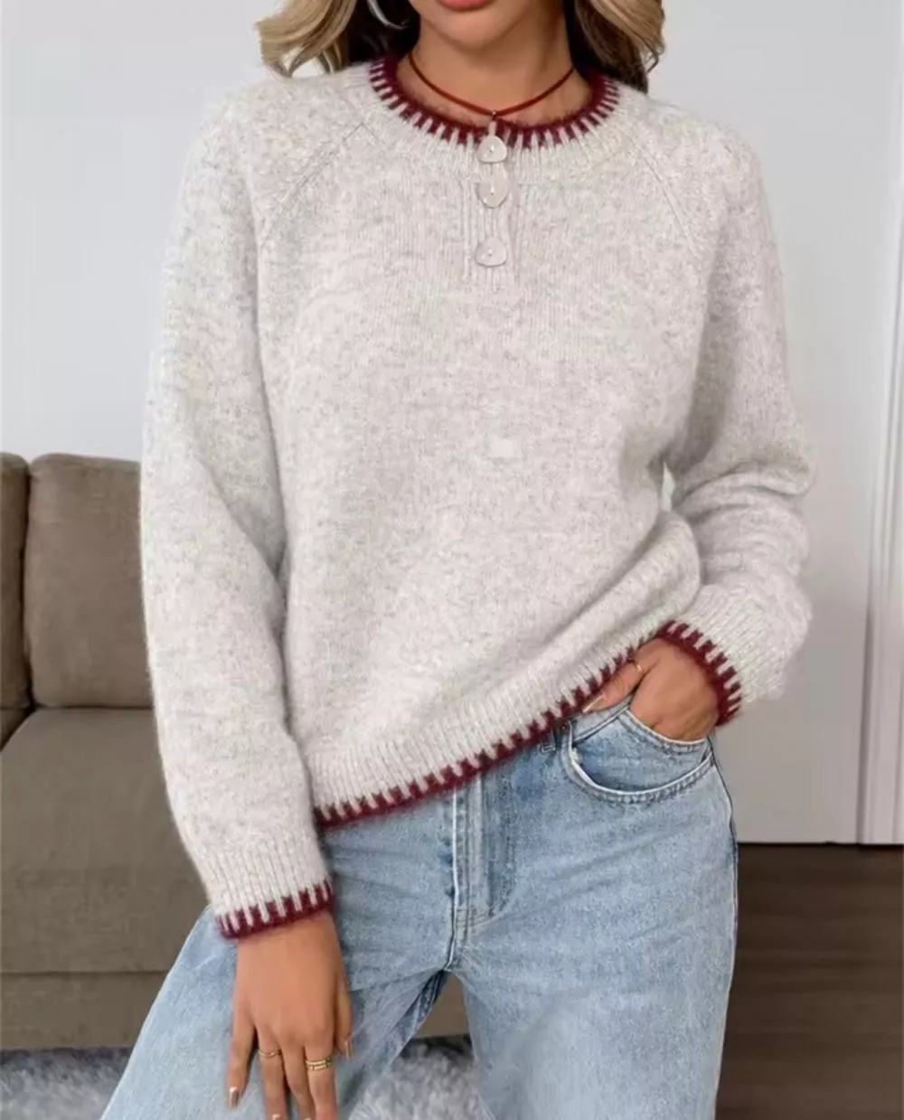 Dettaglio bordo manica e orlo maglione bianco con dettagli bordeaux