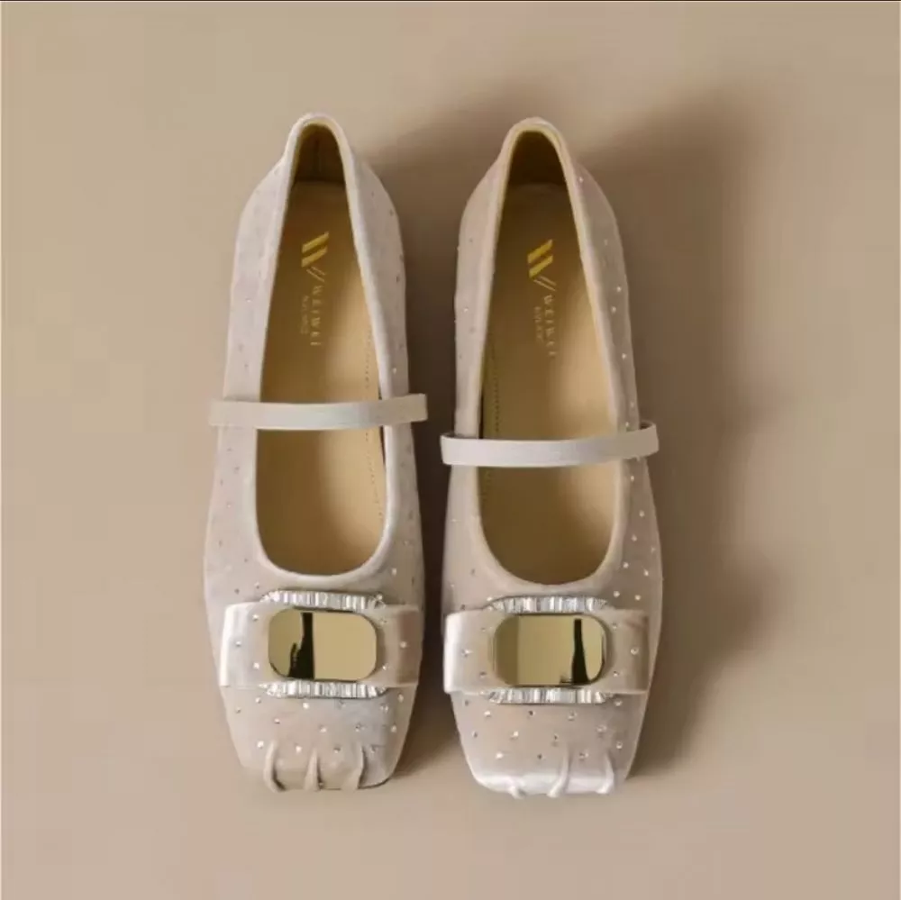 Mocassini donna beige con cinturino elastico indossati ai piedi, vista dall'alto
