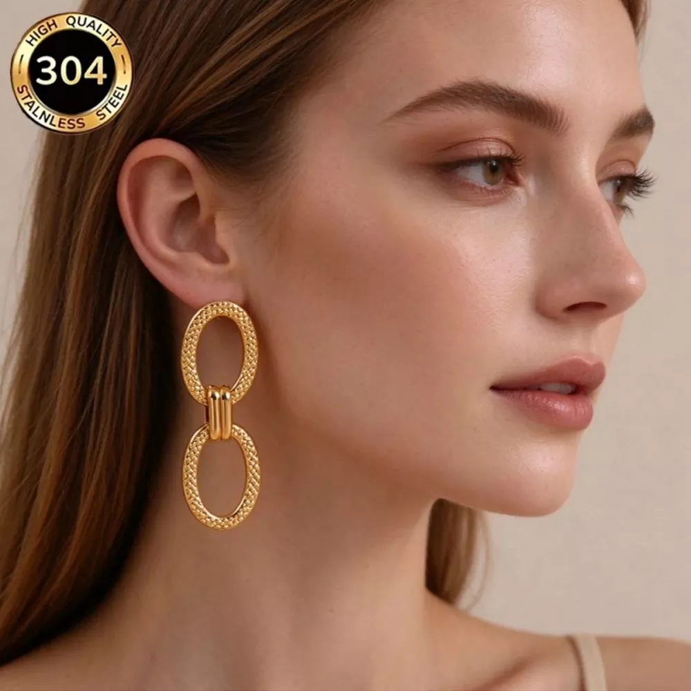 Donna ritratta di profilo con indosso orecchini ovali dorati in acciaio 304 con placcatura oro 18K, design semplice e raffinato