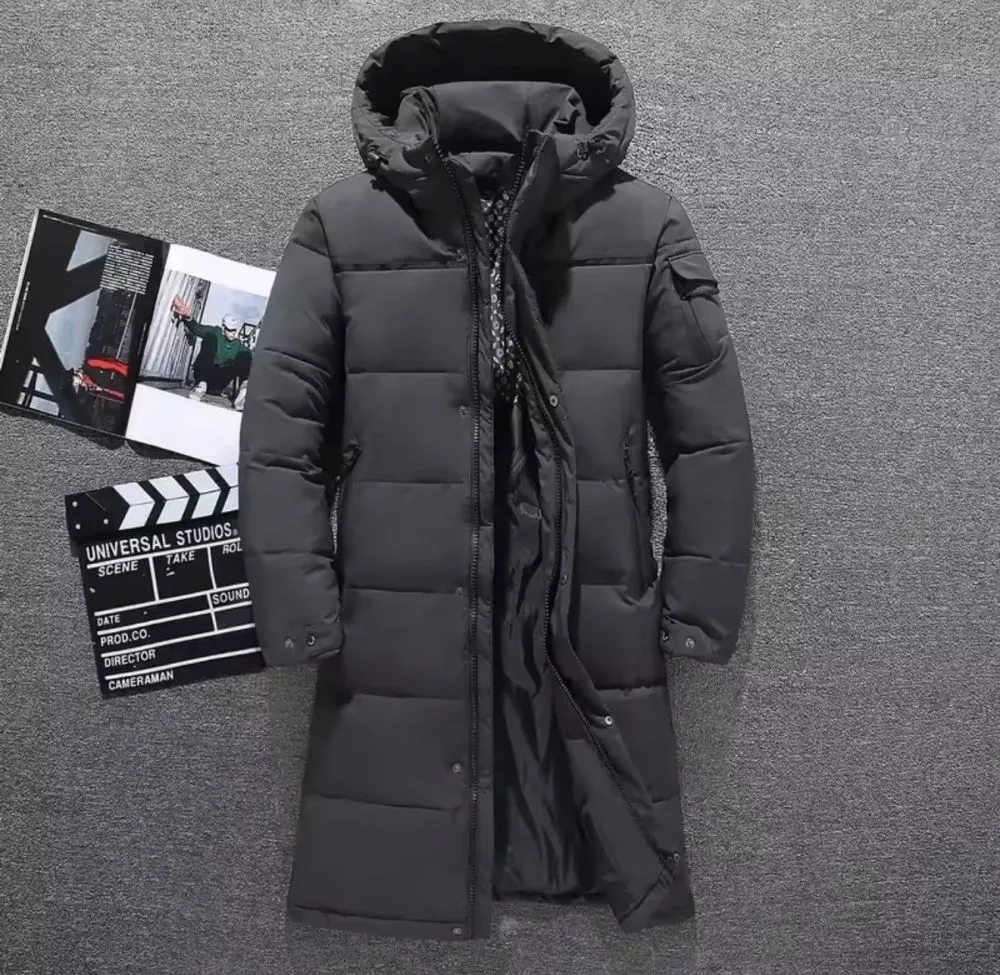 Parka uomo nero imbottito con cappuccio in posizione frontale su superficie grigia