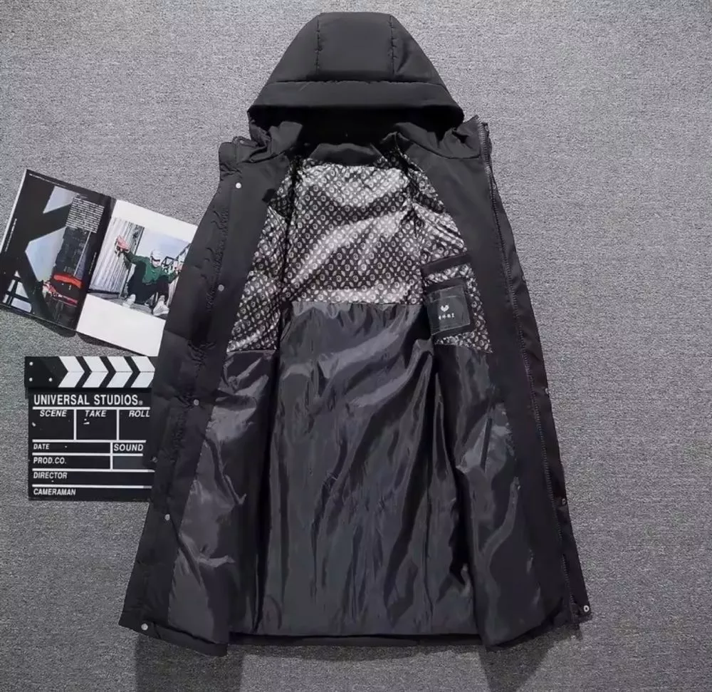 Parka uomo nero imbottito con cappuccio visto da dietro su superficie grigia