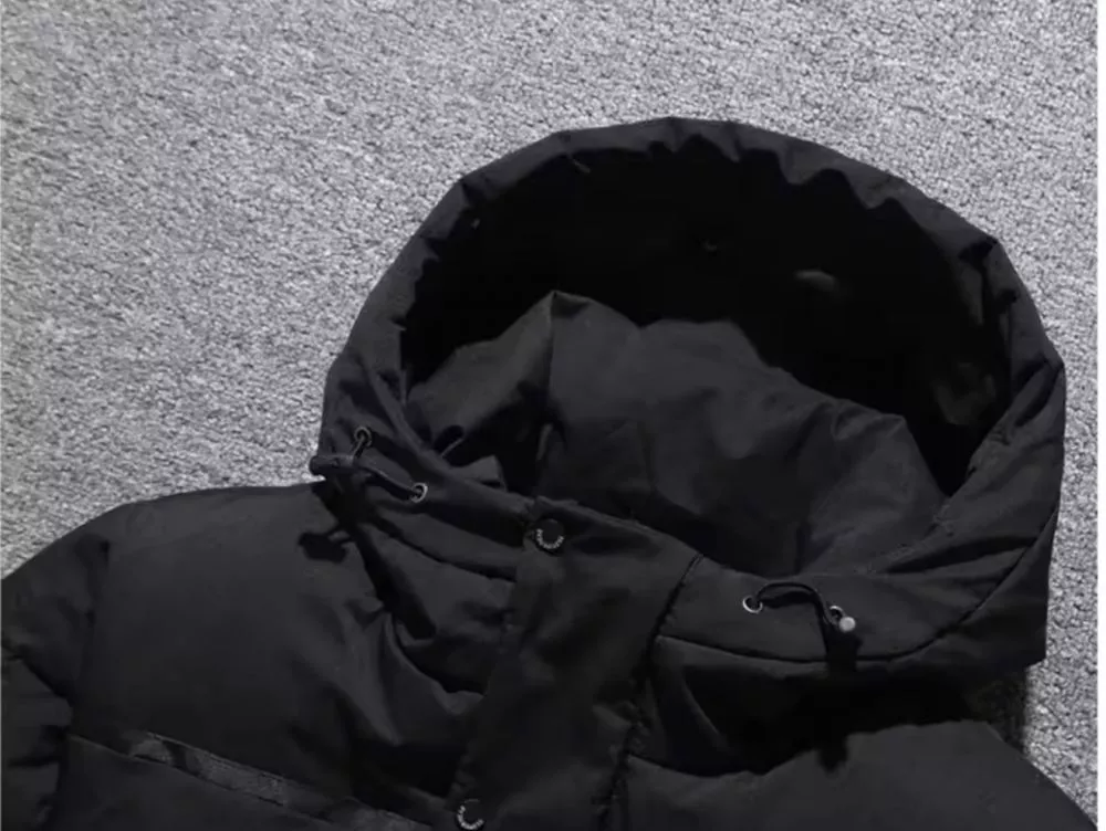 Dettaglio cappuccio parka nero imbottito da uomo con coulisse regolabile