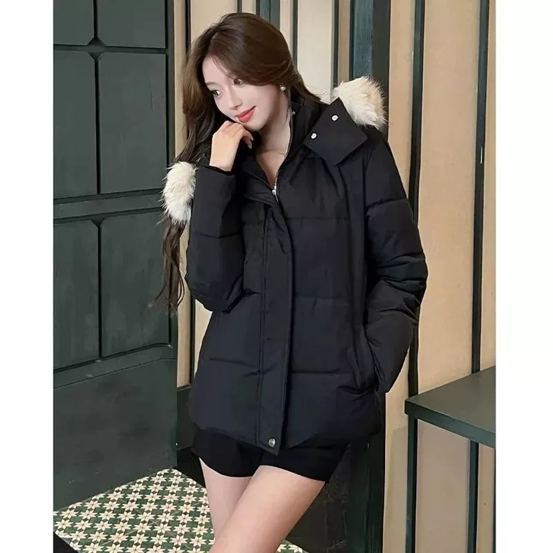 Modella indossa piumino donna nero con cappuccio e pelliccia sintetica