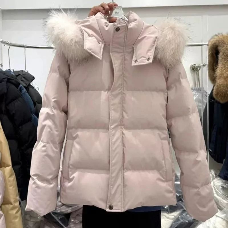 Piumino donna rosa chiaro con cappuccio e pelliccia sintetica appeso