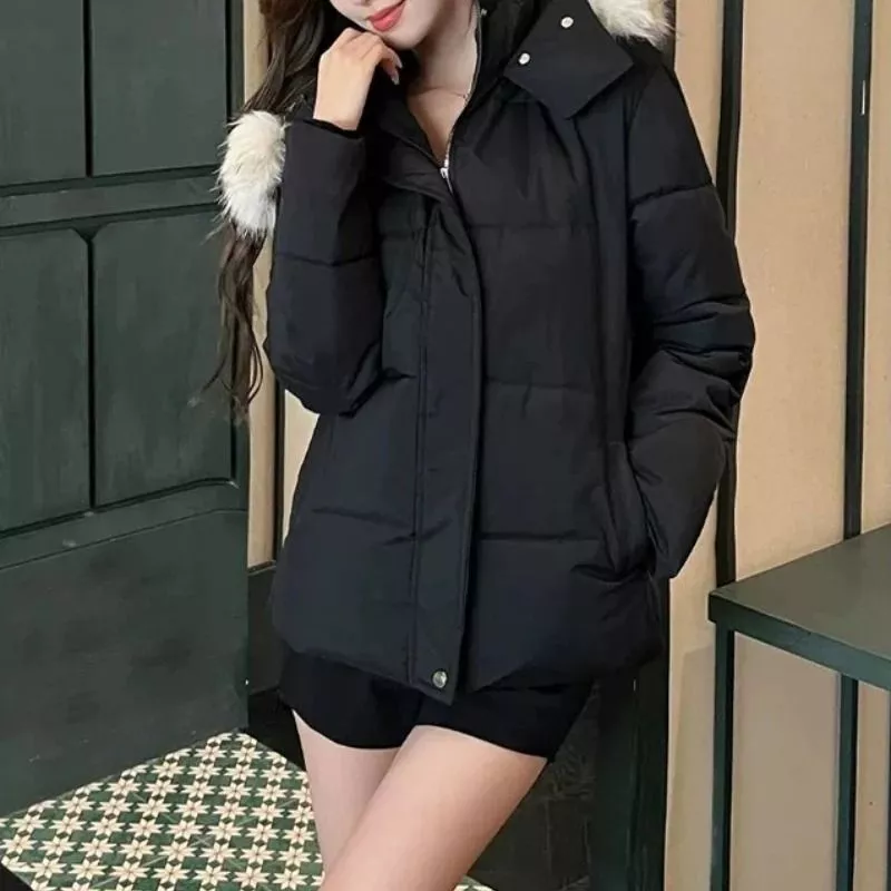 Piumino donna nero con cappuccio e pelliccia sintetica indossato con shorts