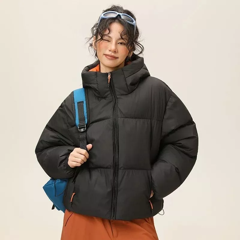 Piumino nero donna con cappuccio e zip frontale, indossato a mezza figura