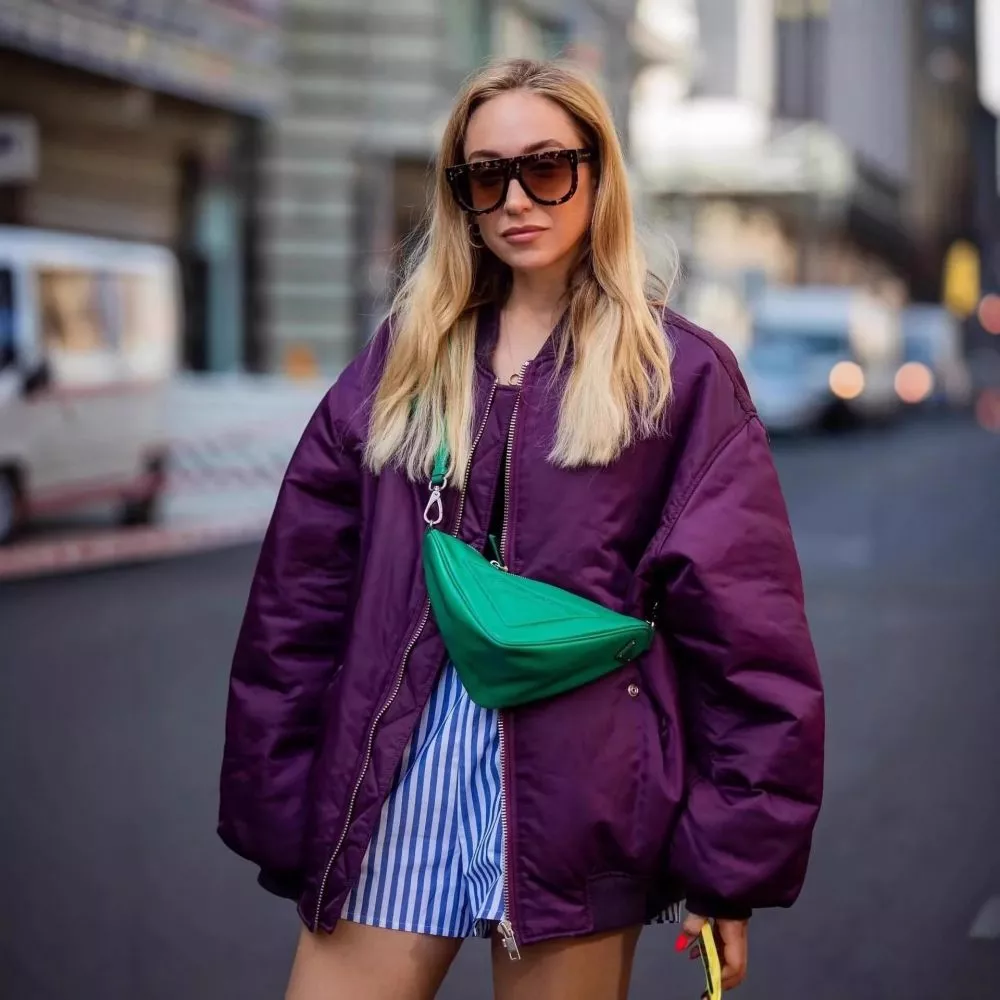 Piumino viola oversize indossato in strada, zip centrale chiusa