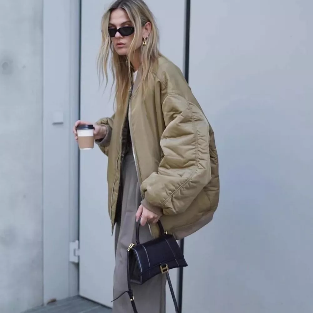 Donna con piumino beige oversize maniche sbuffo, in ambiente urbano