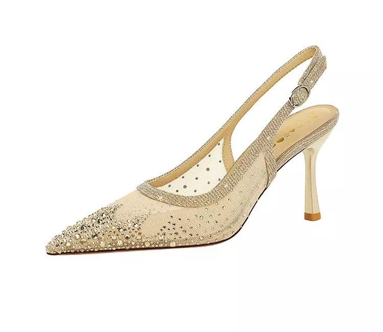 Primo piano sandali donna oro con tacco alto e punta appuntita su sfondo bianco