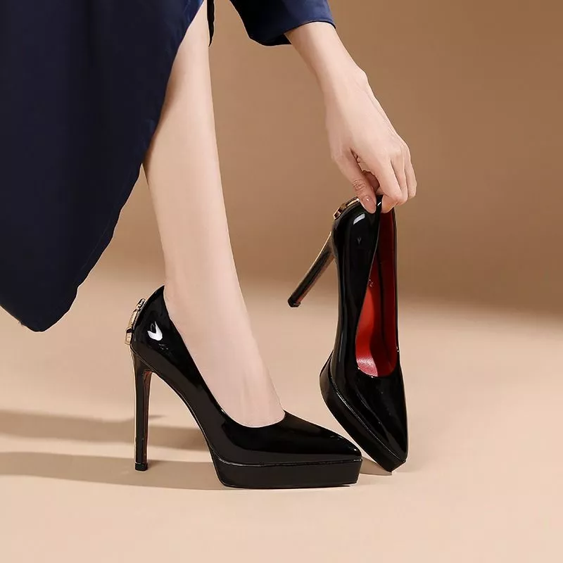 Donna che indossa scarpe decollete nere lucide con tacco alto e plateau
