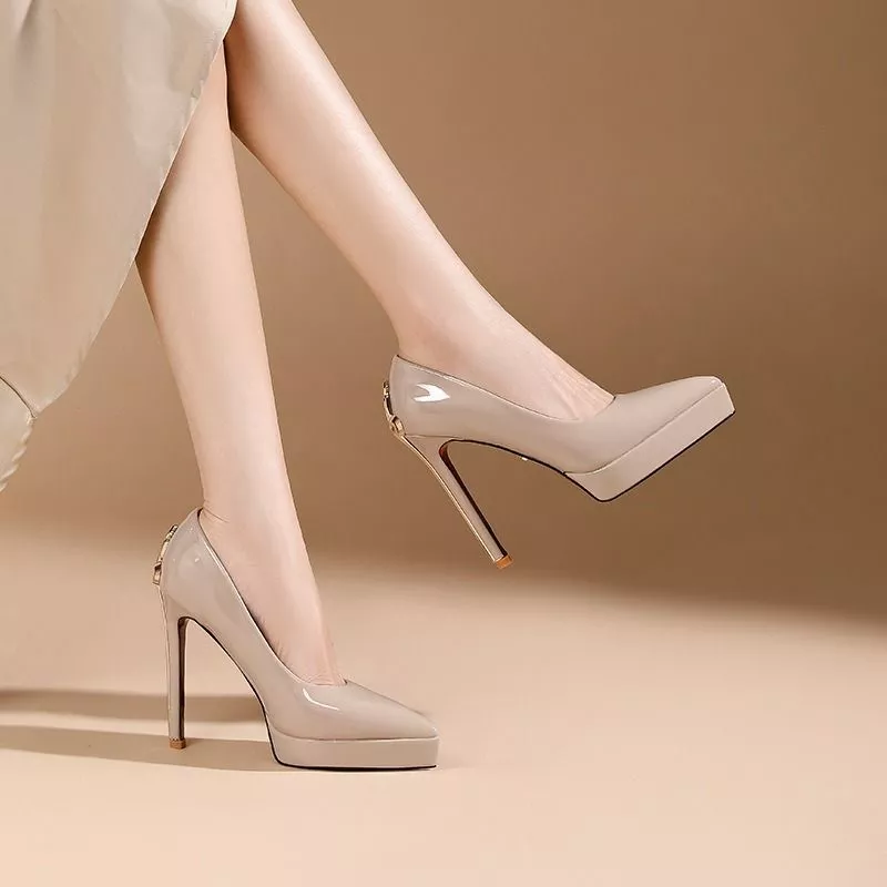 Donna che indossa scarpe decollete beige lucide con tacco alto e plateau