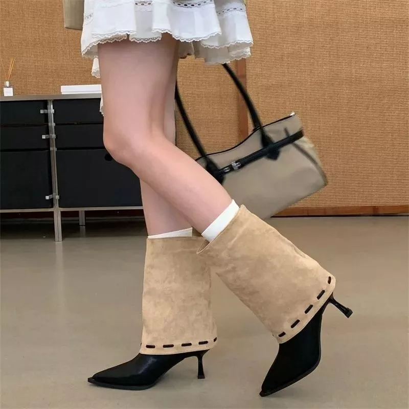 Modella che indossa tronchetti con gambale bianco e punta nera, in materiale sintetico