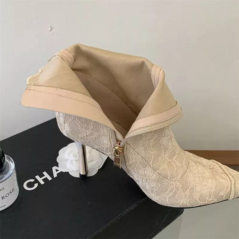 Interno tronchetti beige in pizzo con rivestimento sintetico e zip aperta sopra scatola nera