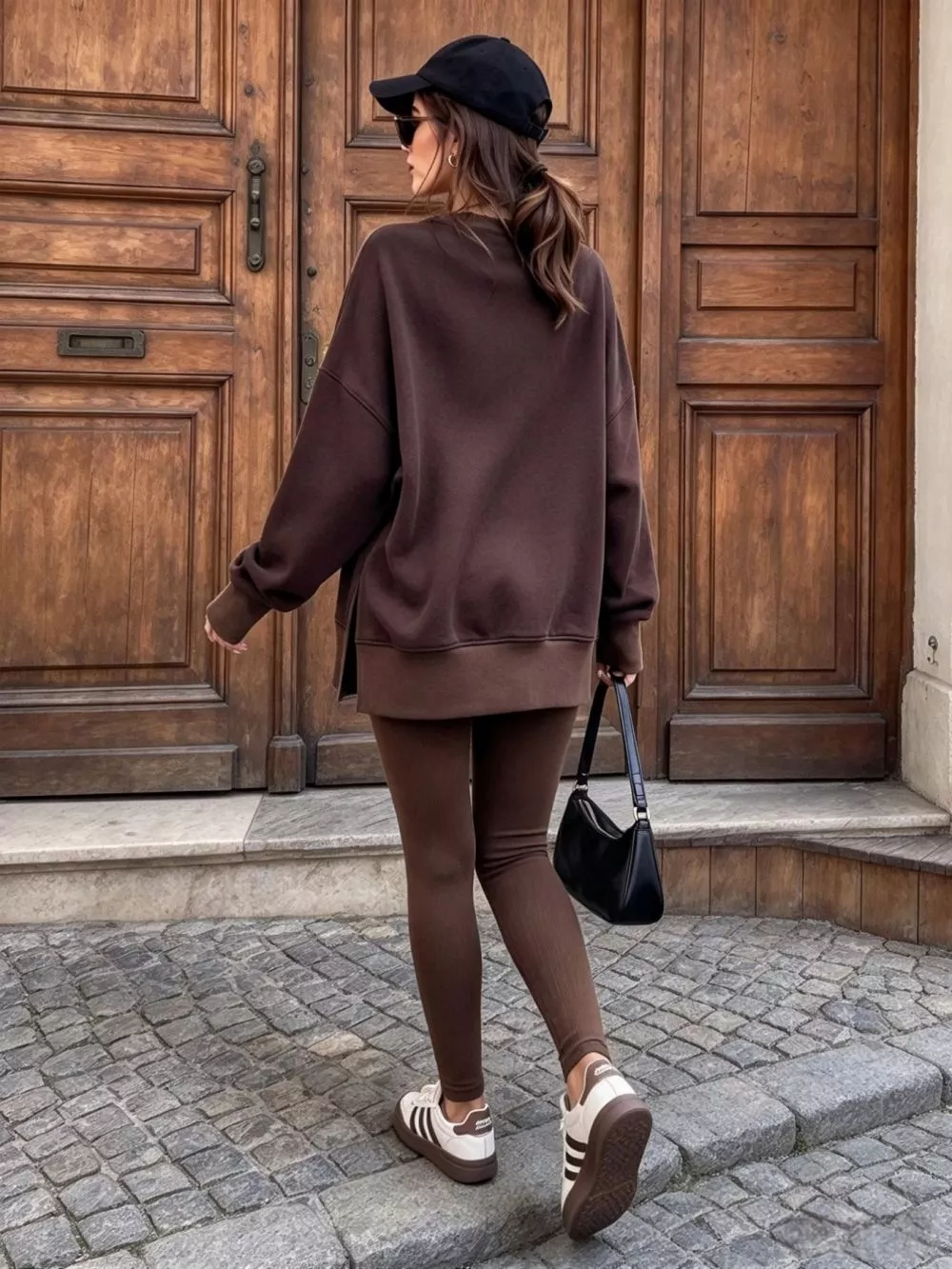 Vista frontale donna con tuta marrone, maglia oversize e leggings a coste